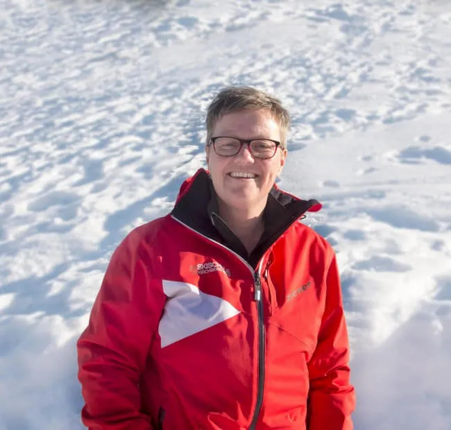 Person im roten Anorak vor schneebedecktem Hintergrund