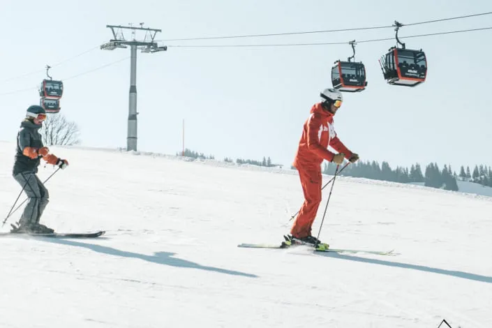 Skifahrer auf der Piste in Kirchberg mit Lift im Hintergrund