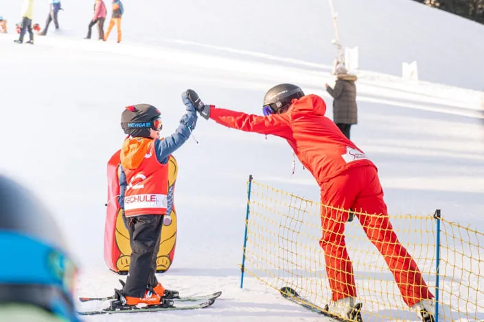 Kind und Skilehrer an der Piste in Kirchberg